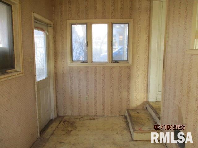 spare room featuring wallpapered walls