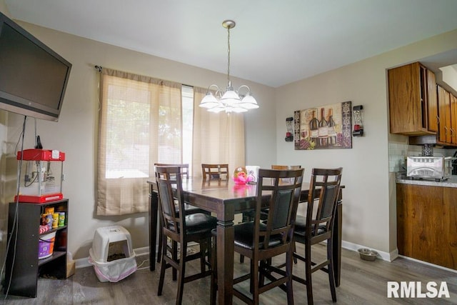 dining area with a chandelier and dark wood-type flooring