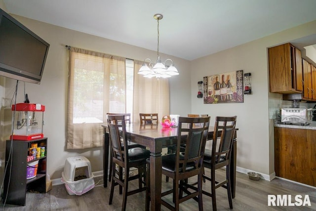 dining room with hardwood / wood-style floors and an inviting chandelier