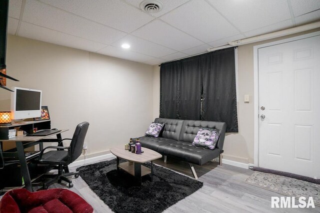 office space with a paneled ceiling and wood-type flooring