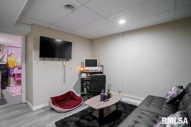 living room featuring hardwood / wood-style floors and a drop ceiling