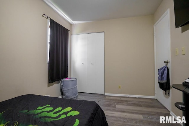 bedroom with light hardwood / wood-style floors and a closet