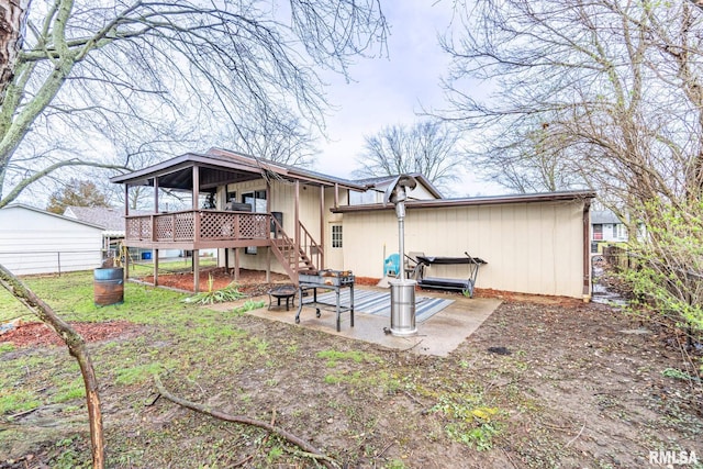 rear view of property featuring a patio area and a wooden deck