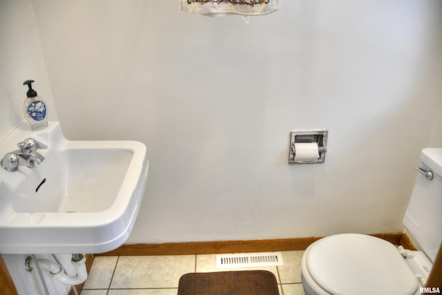 bathroom featuring tile patterned flooring, toilet, and sink