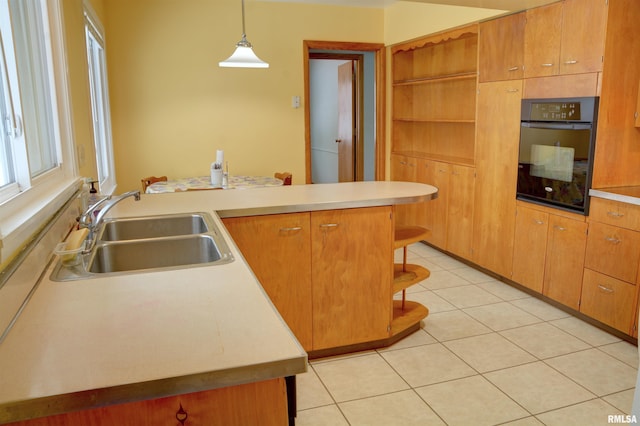 kitchen featuring light tile patterned flooring, decorative light fixtures, oven, and sink