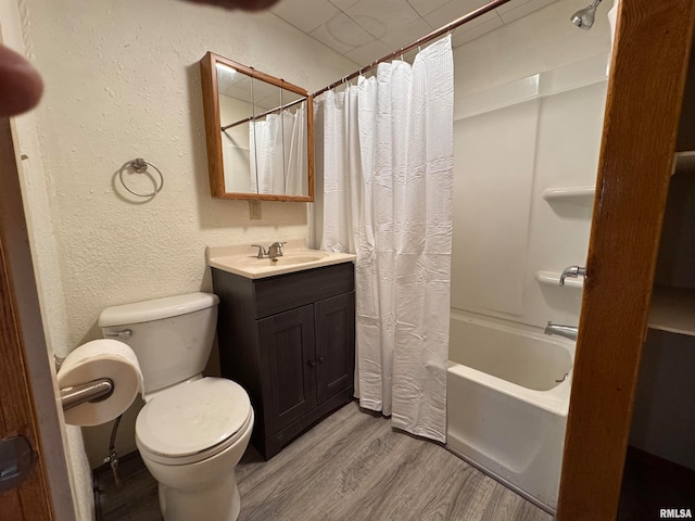 full bathroom featuring hardwood / wood-style flooring, vanity, shower / bath combo, and toilet