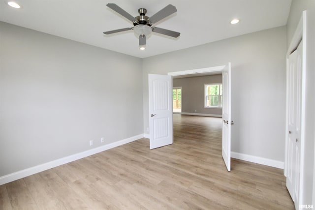 unfurnished bedroom with ceiling fan and light wood-type flooring