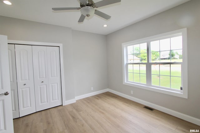 unfurnished bedroom with ceiling fan, light hardwood / wood-style flooring, and a closet