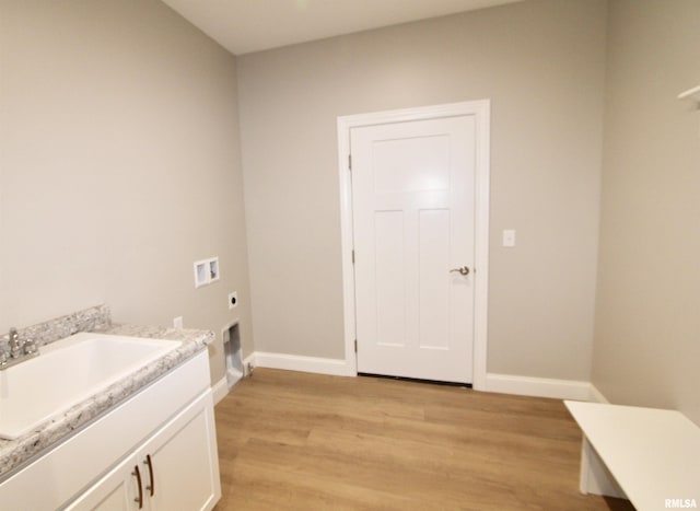 laundry room featuring electric dryer hookup, cabinets, sink, hookup for a washing machine, and light wood-type flooring