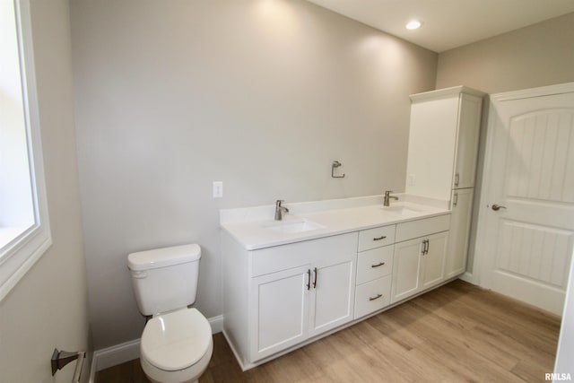 bathroom with hardwood / wood-style floors, vanity, and toilet