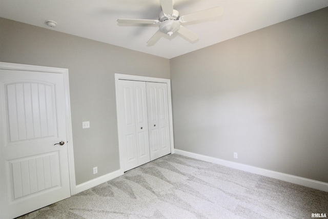 unfurnished bedroom featuring ceiling fan, a closet, and light carpet