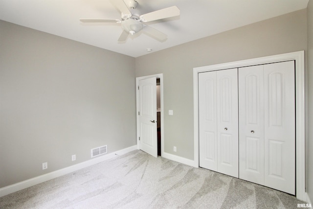 unfurnished bedroom featuring a closet, light colored carpet, and ceiling fan