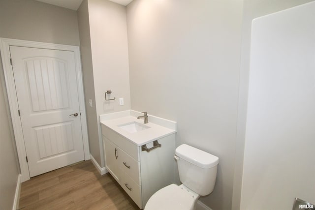 bathroom featuring wood-type flooring, vanity, and toilet