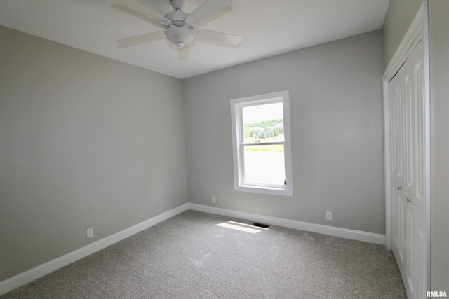 carpeted spare room with ceiling fan