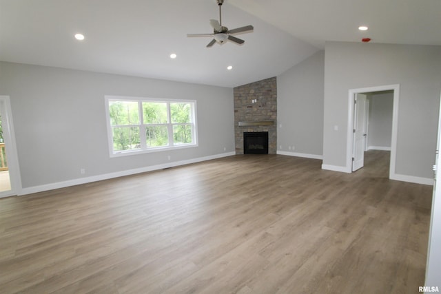 unfurnished living room with ceiling fan, light wood-type flooring, a fireplace, and lofted ceiling