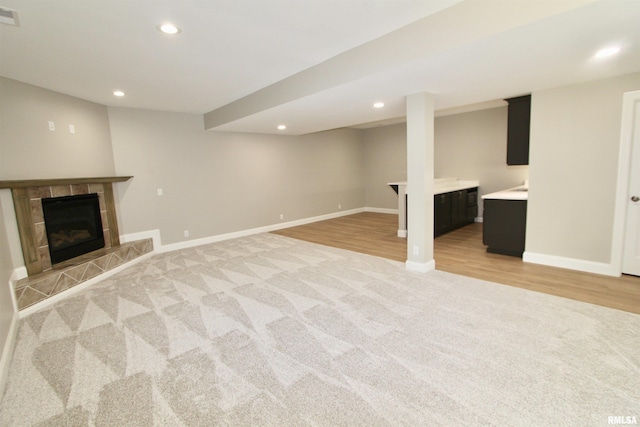 basement featuring a fireplace and light colored carpet