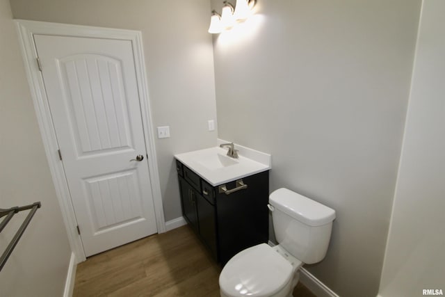 bathroom featuring vanity, hardwood / wood-style flooring, and toilet