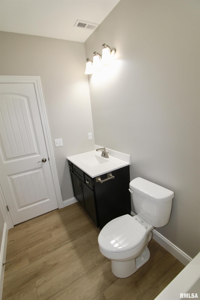 bathroom featuring hardwood / wood-style flooring, vanity, and toilet