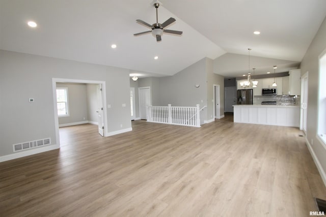 unfurnished living room with ceiling fan, light wood-type flooring, and vaulted ceiling