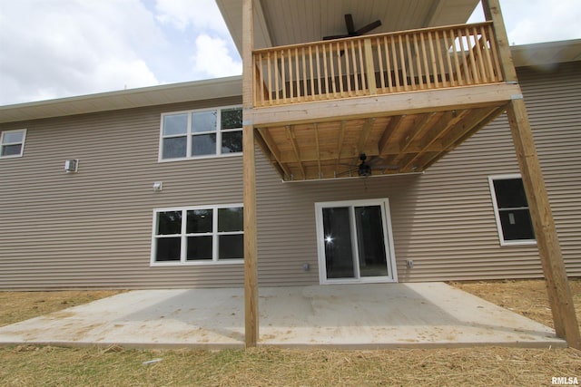 back of house featuring ceiling fan, a balcony, and a patio