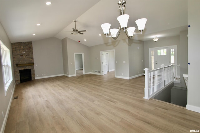 unfurnished living room featuring a fireplace, ceiling fan with notable chandelier, light hardwood / wood-style flooring, and vaulted ceiling