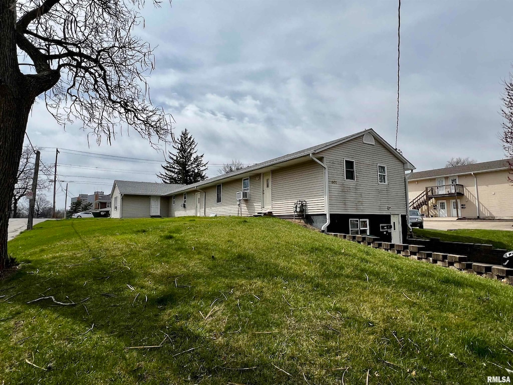 rear view of property featuring a lawn