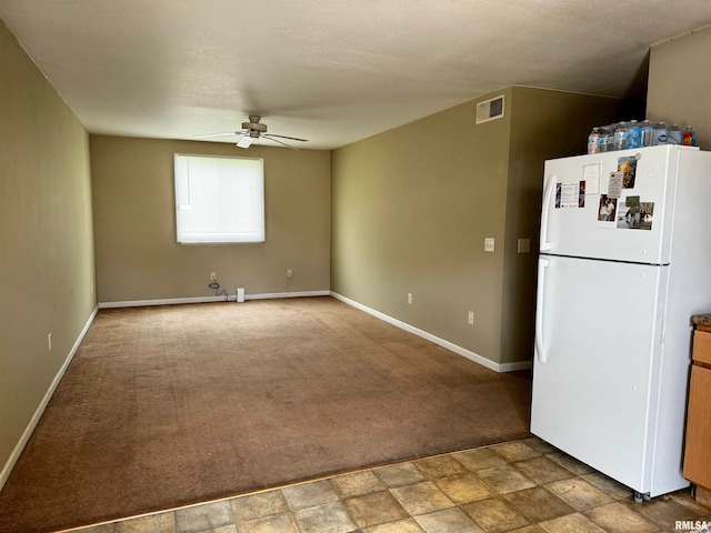 kitchen featuring carpet, ceiling fan, and white fridge