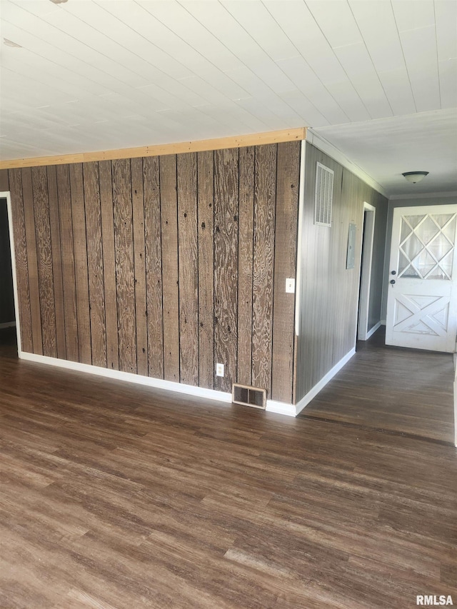 additional living space with dark hardwood / wood-style floors and wood walls