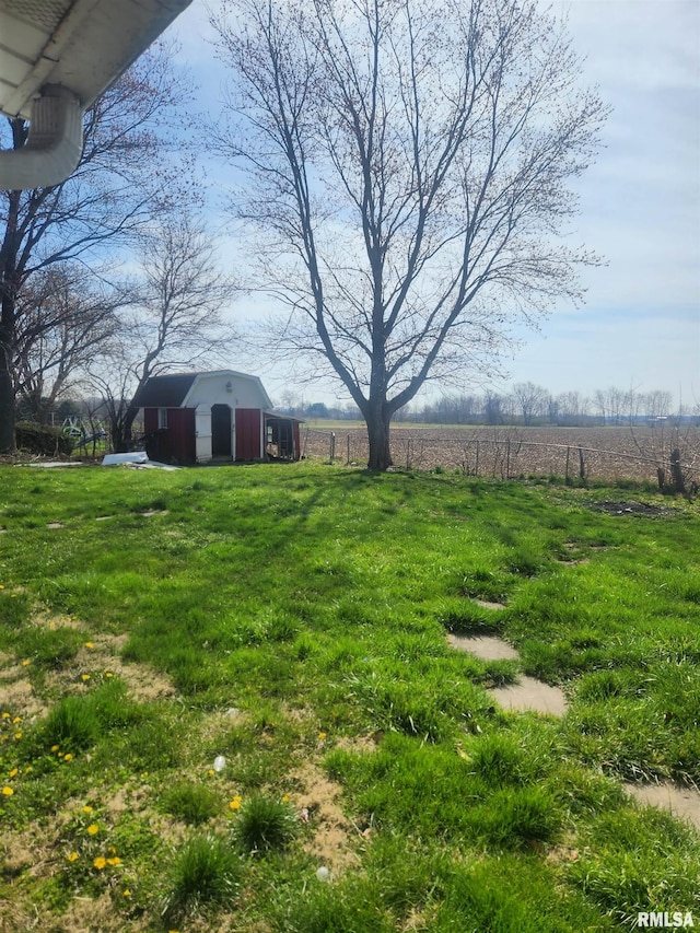 view of yard featuring a rural view and an outdoor structure