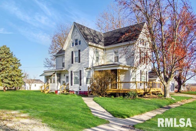 view of front facade featuring a front yard and a wooden deck