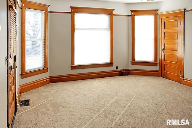 unfurnished room with a healthy amount of sunlight and carpet