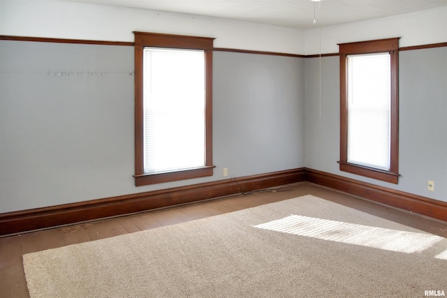 empty room with plenty of natural light and hardwood / wood-style flooring