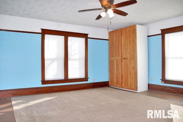 unfurnished room with a healthy amount of sunlight, carpet flooring, and ceiling fan