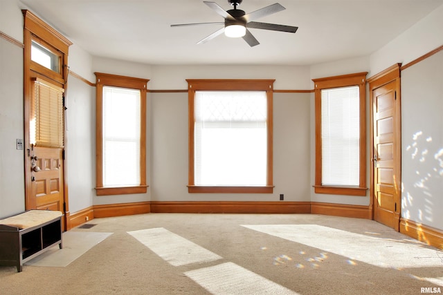 interior space featuring a wealth of natural light, ceiling fan, and carpet floors