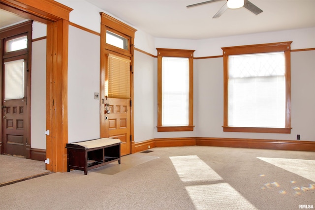 interior space featuring a healthy amount of sunlight, ceiling fan, and carpet