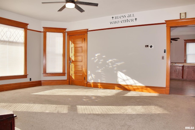 carpeted empty room with plenty of natural light, ceiling fan, and sink