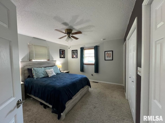 carpeted bedroom featuring ceiling fan and a textured ceiling