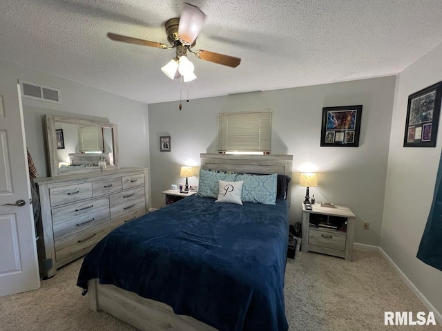 carpeted bedroom with ceiling fan and a textured ceiling