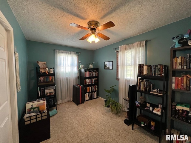 misc room with a textured ceiling, plenty of natural light, ceiling fan, and carpet floors