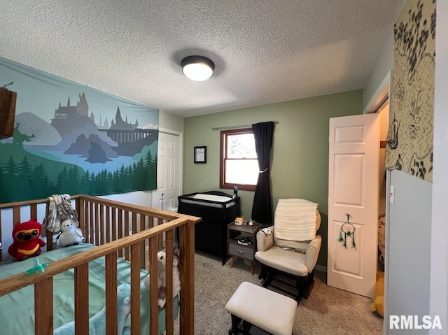 bedroom featuring a textured ceiling, carpet, and a crib