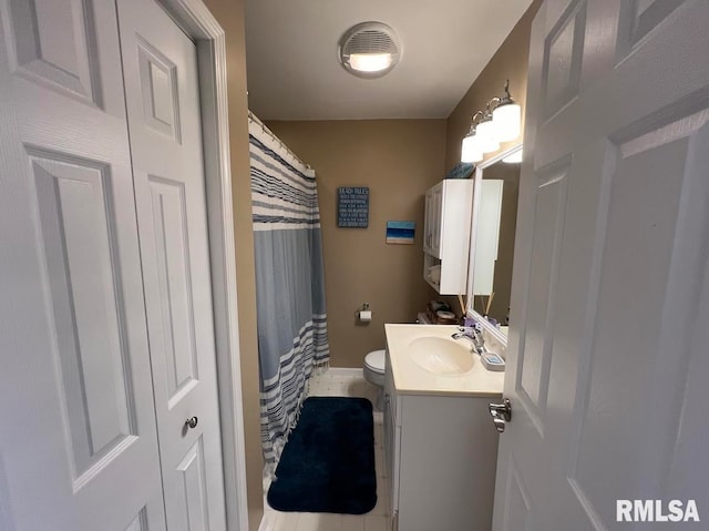 bathroom featuring tile patterned floors, vanity, and toilet