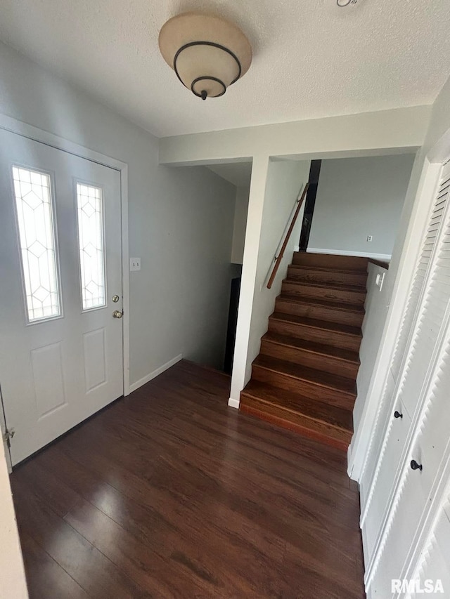 entrance foyer featuring a textured ceiling and dark wood-type flooring