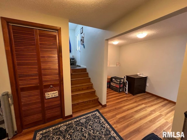 stairway featuring wood-type flooring and a textured ceiling