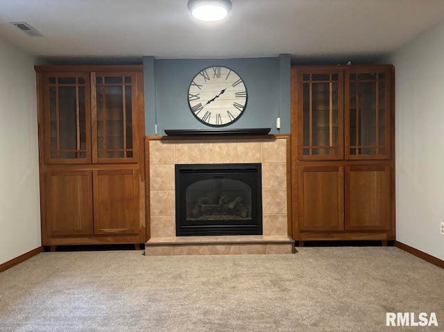 unfurnished living room with a tile fireplace and carpet floors