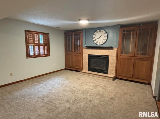 unfurnished living room with a tiled fireplace and light carpet