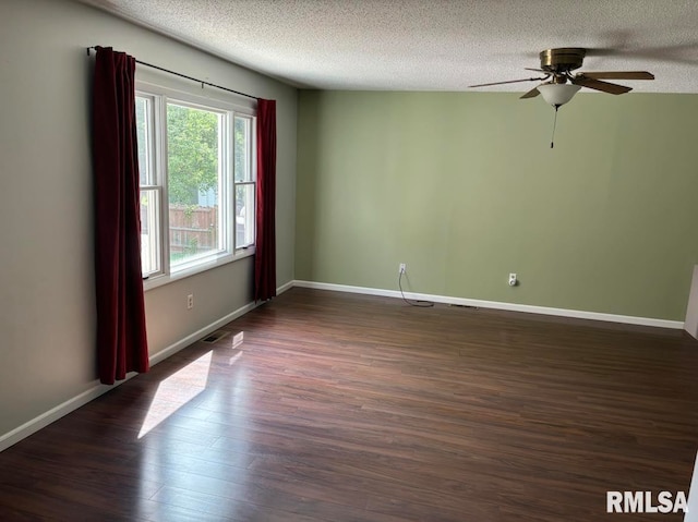 unfurnished room with ceiling fan, dark wood-type flooring, and a textured ceiling