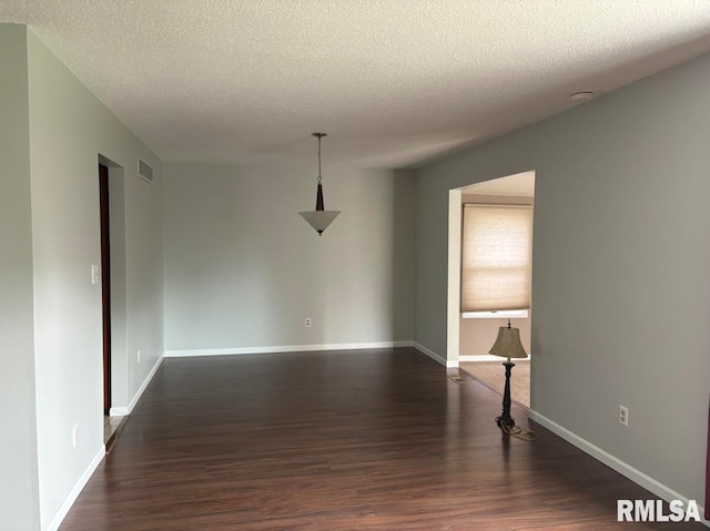 unfurnished room featuring a textured ceiling and hardwood / wood-style floors