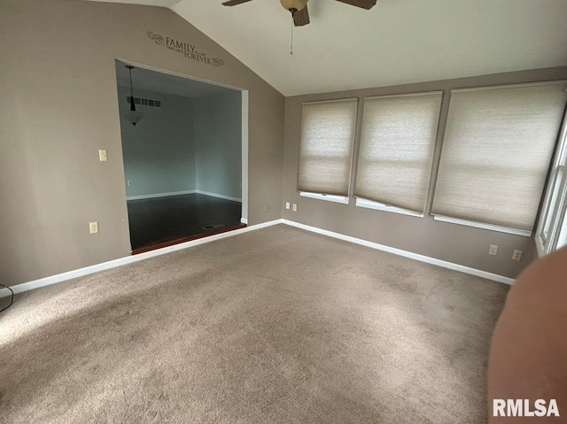 spare room with ceiling fan, vaulted ceiling, and carpet flooring