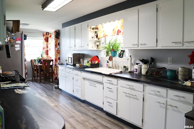 kitchen featuring stainless steel fridge, white cabinetry, and light wood-type flooring