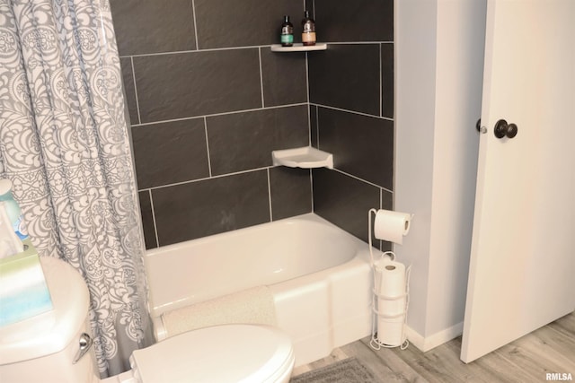 bathroom with wood-type flooring, shower / bath combo with shower curtain, and toilet